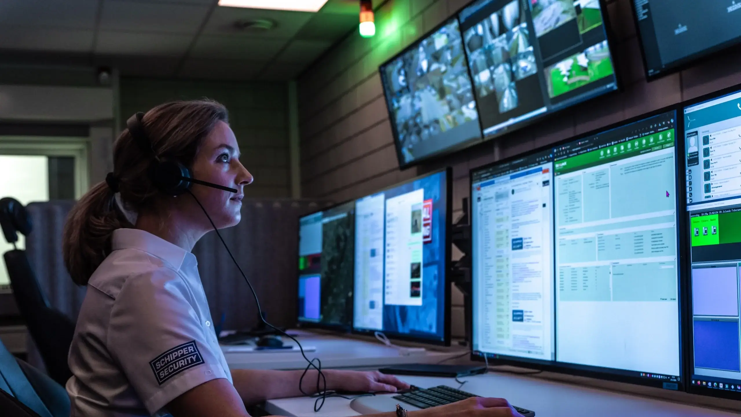 Centralist achter bewakingsschermen op de meldkamer